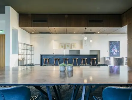 Chic office space rental in Eindhoven Strijp-S with a modern interior featuring a large table, stylish barstools, and contemporary decor at Achtseweg Zuid 159R.