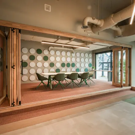 Modern office space rental in Eindhoven Strijp-S with a stylish meeting room featuring distinctive circular wall designs and contemporary furnishings.