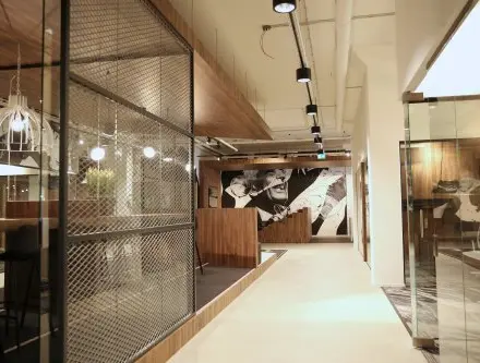 Modern office space at Frederiklaan 10E, Eindhoven Strijp-S, featuring artistic decor, glass walls, and seating areas available for office space rental.