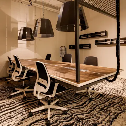 Spacious office to rent at Frederiklaan 10E, Eindhoven Strijp-S, featuring a modern conference room setup with a large wooden table and contemporary chairs.