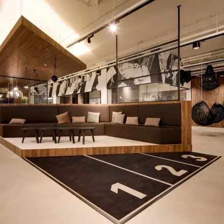 Modern office to rent at Frederiklaan 10E, Eindhoven Strijp-S, featuring a stylish seating area with contemporary furnishings and artistic decor. Ideal for office space rental in a vibrant setting.