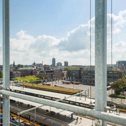 Exterior view overlooking Enschede cityscape from Brandweerstraat 20-30, offering a glimpse of nearby train tracks and urban surroundings.