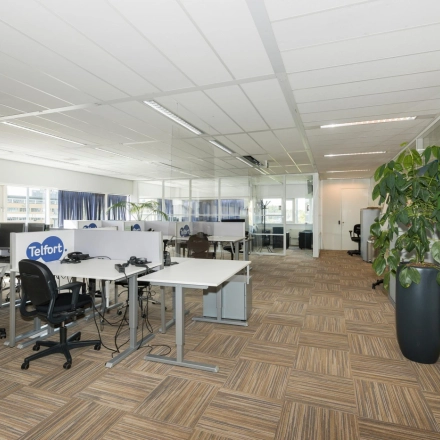 Bright open-plan office space with modular workstations and glass partitions at Brandweerstraat 20-30, Enschede. Ideal for businesses seeking flexible office space rental.