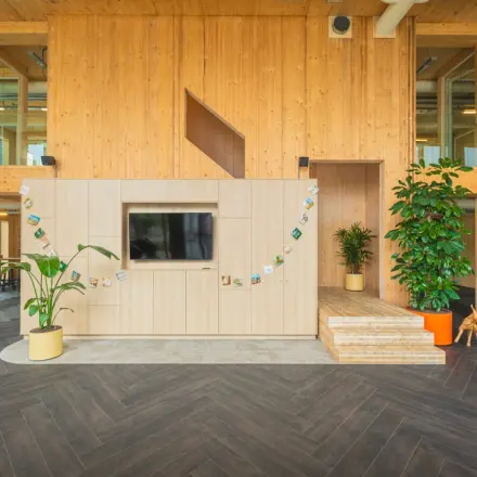 Inviting office space with wooden accents, indoor plants, and a display area at Moutlaan 1-23, Enschede, perfect for office space rental.