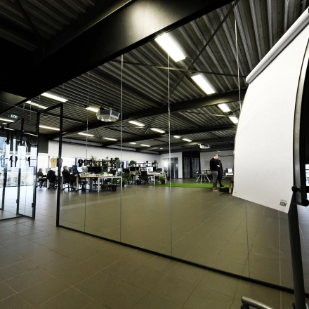Spacious office to rent at Parkweg 102, Enschede featuring modern desks, sleek glass partitions, and collaborative workstations. Ideal for businesses seeking office space rental.
