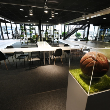 Spacious and modern office to rent at Parkweg 102, Enschede, featuring ample seating and unique decorative elements like a vintage football display.