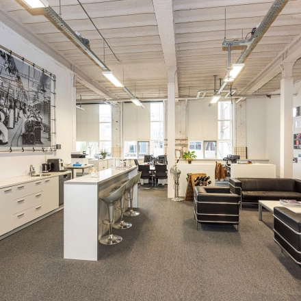 Modern office space in Enschede featuring comfortable seating, high ceilings, and natural light. Ideal for businesses seeking office space rental with stylish furnishings.