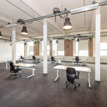 Furnished office space for rent at Rigtersbleek-Zandvoort 10, Enschede, featuring multiple desks and chairs in an open-plan layout.