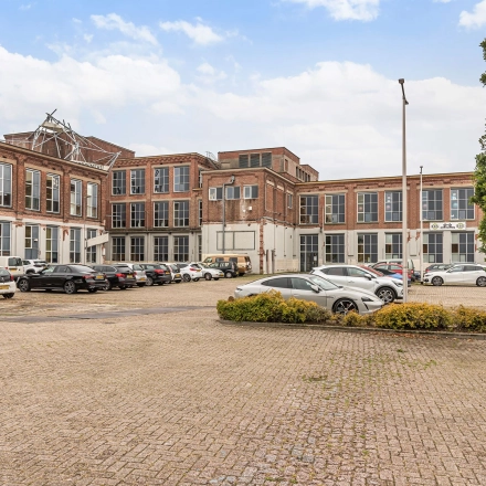 Exterior view of the office building located at Rigtersbleek-Zandvoort 10, Enschede, showcasing available office space rental with ample parking.