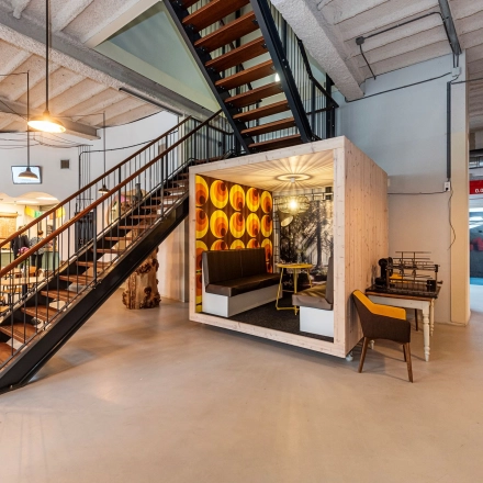 Modern office space at Rigtersbleek-Zandvoort 10, Enschede featuring a stylish meeting area under a staircase, ideal for rent office space options.