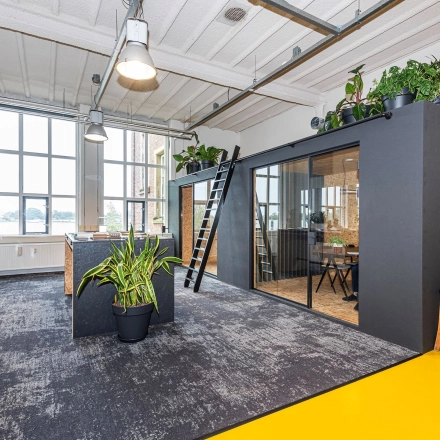 Modern office on Rigtersbleek-Zandvoort 10, Enschede with a bright, open floorplan featuring large windows and contemporary furnishings. Ideal office space rental for a creative work environment.