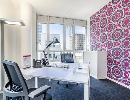 Bright office space with a desk, chair, and vibrant patterned wall, perfect for office space rental at Mergenthaler Allee 15-21, Eschborn.