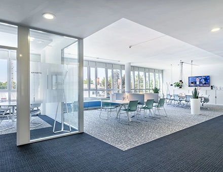 Spacious office to rent at Mergenthaler Allee 15-21, Eschborn, featuring a bright, open floorplan with modern furniture and large windows.