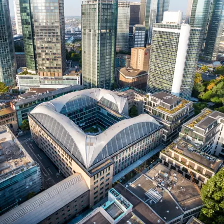 Aerial view of office building located at Neue Rothofstraße 13-19 in Frankfurt Center, surrounded by tall skyscrapers, ideal for office space rental.