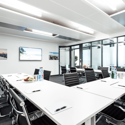 Spacious conference room at Mainzer Landstraße 69, Frankfurt Central Station, featuring a modern design with a long table and sleek chairs, ideal for office space rental and professional meetings.