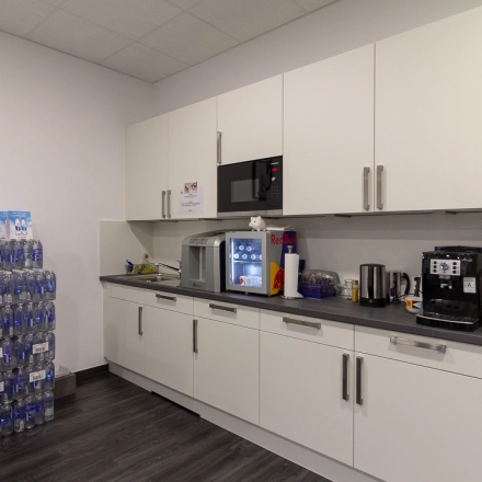 Office pantry at Eschborner Landstraße 42-50 in Frankfurt West with appliances and bottled water. Ideal space for office space rental.