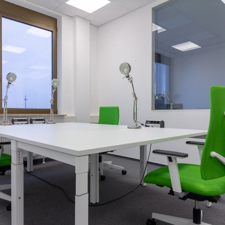 Bright office space at Eschborner Landstraße 42-50, Frankfurt West, featuring a modern setup with green chairs and desks suitable for office space rental.