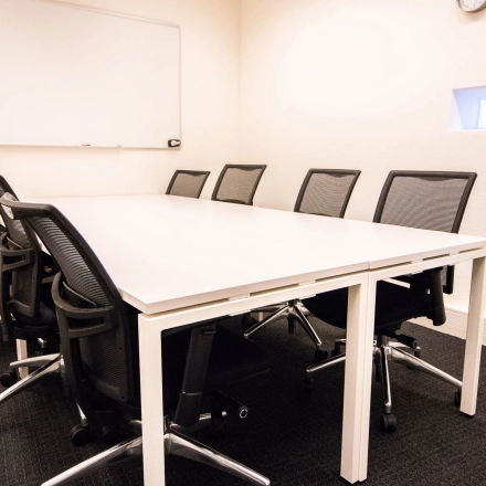 Office space rental at Kampenringweg 45, Gouda, featuring a meeting room with a large table, multiple chairs, and a whiteboard, perfect for collaborative sessions.