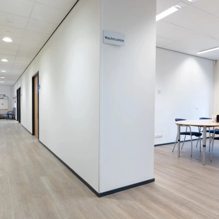Interior office space at Zuidelijk Halfrond 1, Gouda featuring a hallway and a small furnished meeting area, ideal for office space rental.