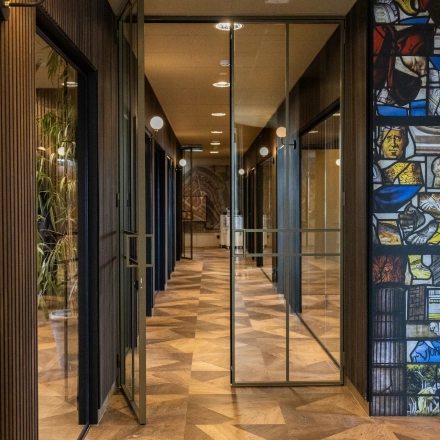Stylish hallway in an office to rent at Zuidelijk Halfrond 1, Gouda, featuring glass doors and decorative wall art.