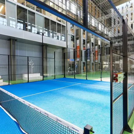 Spacious indoor area featuring a professional paddle court, ideal for employees to unwind during work breaks at Helperpark 270-298, Groningen. Perfect blend of recreational and office space rental options.