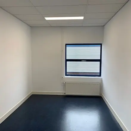 Empty office to rent at Nijverheidsweg 50, Haarlem Oost, featuring a single window and dark flooring.