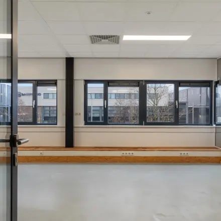 Bright office space with large windows at Waarderweg 52, Haarlem Waarderpolder, available for rent. Simple interior with natural light, perfect for creating a productive environment.
