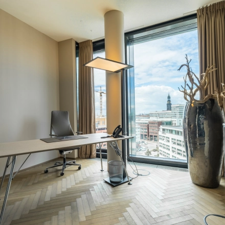 Bright office space rental with modern furnishings and large windows overlooking Hamburg Neustadt at Hohe Bleichen 8.