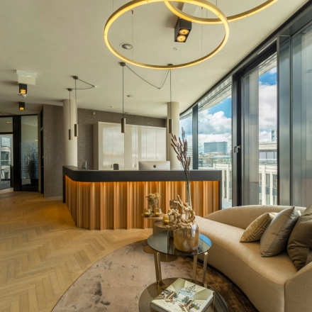 Sophisticated, furnished office lounge at Hohe Bleichen 8, Hamburg Neustadt, showcasing a modern seating area with panoramic windows. Ideal for office space rental.