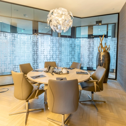 Furnished conference room at Hohe Bleichen 8 in Hamburg Neustadt, ideal for office space rental, featuring a round table, chairs, and a decorative lighting fixture.