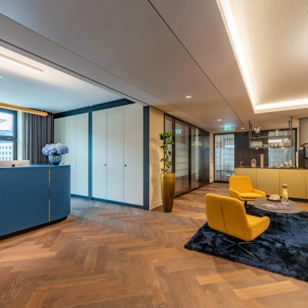 Bright reception area at Alter Wall 32, Hamburg Old Town. Features sleek decor and vibrant seating, ideal for office space rental.