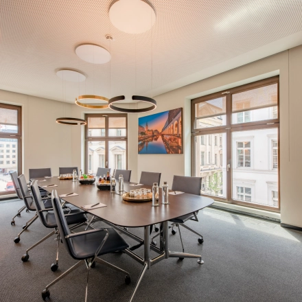 Bright conference room at Alter Wall 32, Hamburg Old Town with a large table and modern chairs, suitable for anyone looking to rent office space.