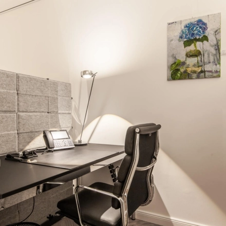 Furnished office space rental at Ballindamm 39, Hamburg Old Town, featuring a sleek desk and chair with modern decor.