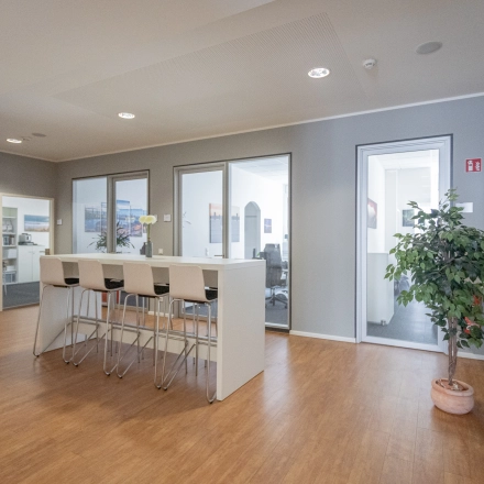 Interior office at Raboisen 38 in Hamburg Old Town with a high table and chairs. Ideal office space rental, featuring a modern and minimal design.