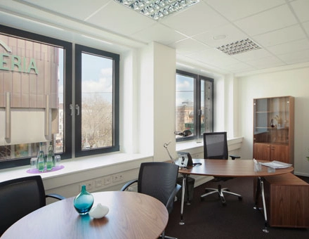 Bright office space rental at Bahnhofstraße 8, Hannover Mitte, featuring modern desks and large windows allowing natural light.