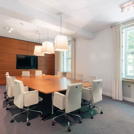 Contemporary conference room at Ceintuurbaan 2, Harderwijk, featuring a sleek wooden table, modern chairs, and a large window allowing natural light. Ideal for office space rental.
