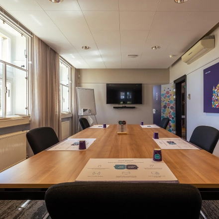 Bright conference room at Ceintuurbaan 2, Harderwijk, featuring a large wooden table, chairs, and wall-mounted screen, perfect for office space rental.