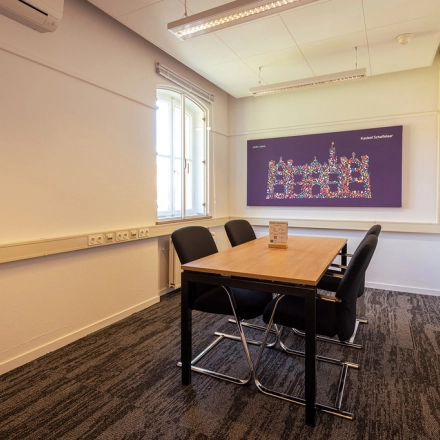 A modest, well-lit conference room in Harderwijk at Ceintuurbaan 2 featuring a table and chairs, suitable for small meetings. Ideal for those seeking office space rental.
