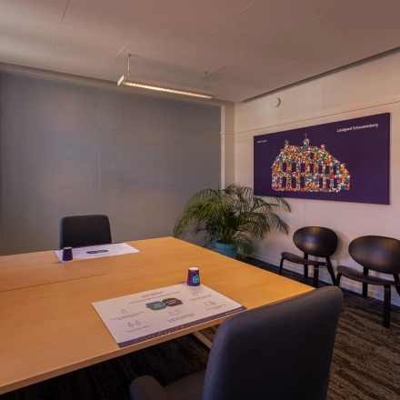 Modern office space at Ceintuurbaan 2, Harderwijk features sleek wooden tables, black chairs, and vibrant wall art, perfect for dynamic meetings. Ideal for office space rental seekers.