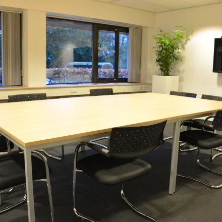 Furnished office space at Herenweg 115, Heemstede, featuring a large table and chairs suitable for meetings or collaborative work. Ideal for office space rental.