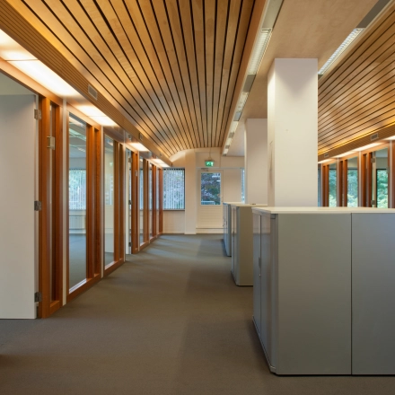 Office space for rent at Herenweg 115 in Heemstede featuring a corridor with wooden accents, glass doors, and ample natural light.