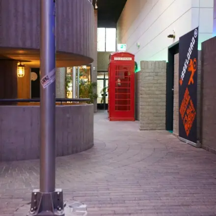 Stylish office interior featuring a red phone booth and unique architectural elements at Catharina van Renneslaan 8-10, ideal for those looking to rent office space in Hilversum.