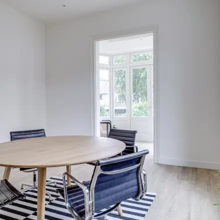 Modern office space at Graaf Florislaan 40, Hilversum, featuring a round table and stylish chairs, ideal for office space rental.