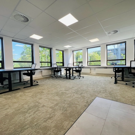 Spacious office to rent at Marathon 2, Hilversum, featuring large windows, several desks, and ergonomic chairs for optimal office space rental.