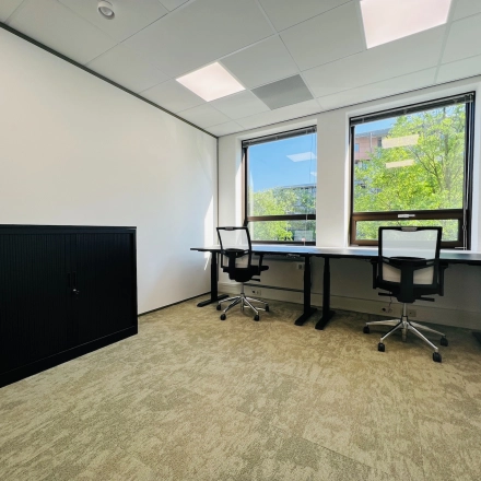 Bright office space at Marathon 2, Hilversum, featuring two desks with office chairs and a cabinet, ideal for office space rental.