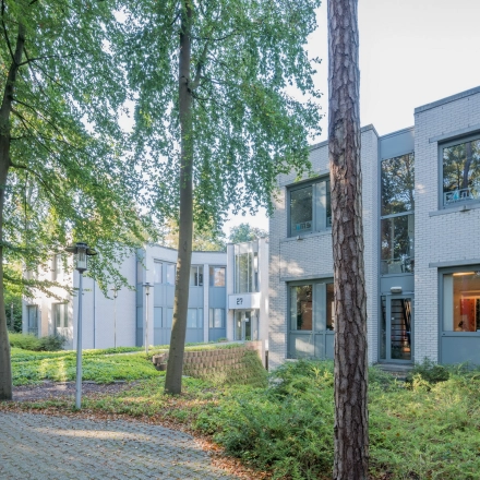 Exterior view of an office building at Mozartlaan 27, Hilversum, surrounded by trees, perfect for office space rental.