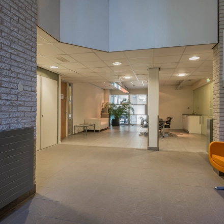 Spacious office area at Mozartlaan 27 in Hilversum, ideal for office space rental with a few workstations, bright lighting, and modern seating.
