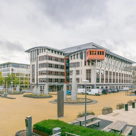 Exterior view of Olympia 1 in Hilversum with modern architecture, ideal for office space rental. Ample outdoor area provides a welcoming environment.