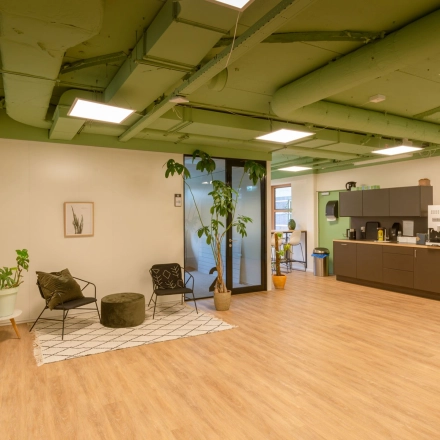 Furnished office space at Olympia 1 in Hilversum featuring a lounge area with chairs and plants, ideal for office space rental.