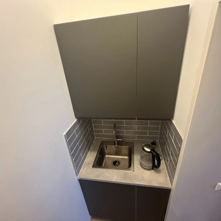 Compact kitchenette with a sink and kettle located in an office space rental at Oude Enghweg 8, Hilversum.